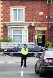Police guard the cordon to Wake Road. Image credited to the Press Association via The Mirror